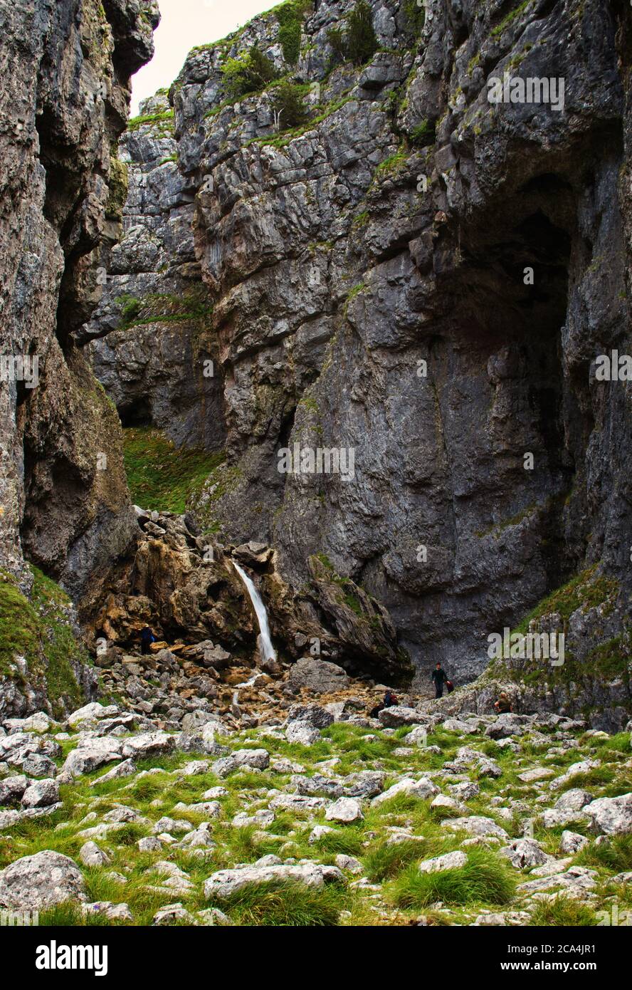 A waterfall dwarfed by the height of Gordale Scar, in the Yorkshire Dales Stock Photo