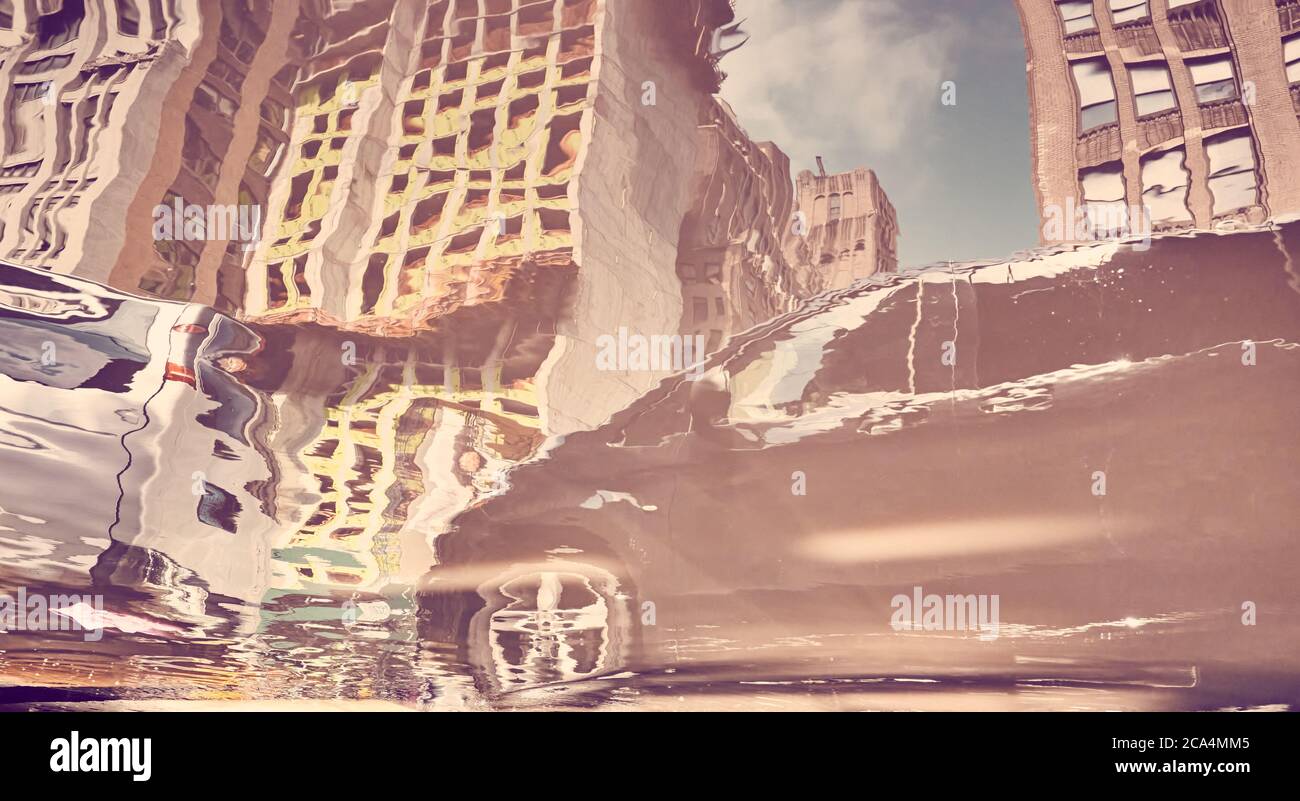 Blurred and distorted view of a car in New York City reflected in puddle, color toning applied, USA. Stock Photo