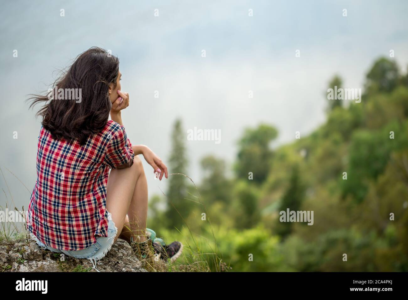 sad unhappy depressed girl sitting on the top of the mountain, back view  photo. copy space. loneliness, depression, blurred background Stock Photo -  Alamy