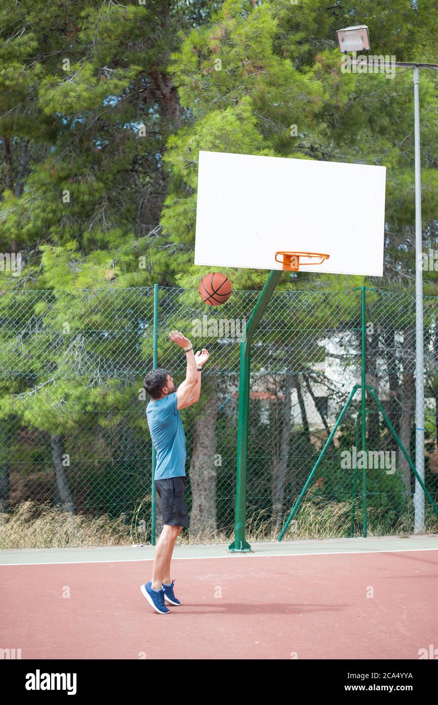 Muscle man playing basketball alone Stock Photo - Alamy
