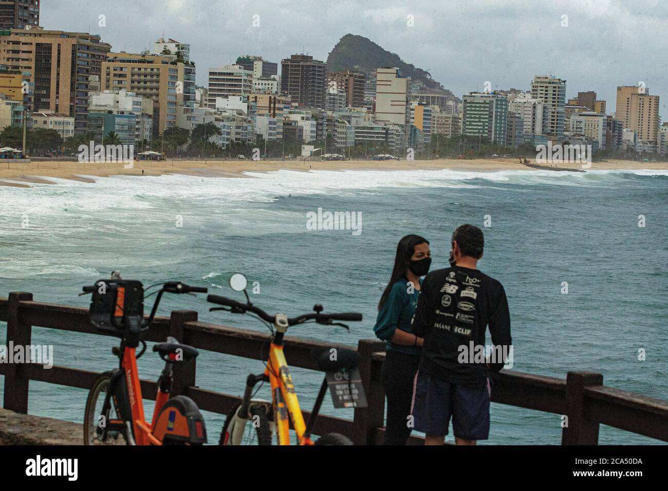 Rio de Janeiro, Brazil   May 21, 2020 A couple  wearing masks enjoy the sun at Leblon beach Stock Photo