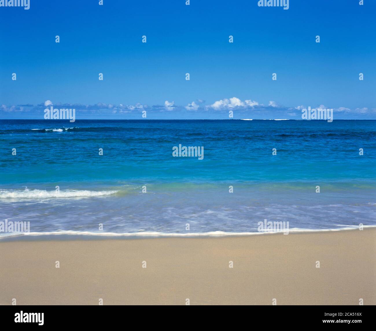 Sandy beach and blue sea with clear line of horizon in background, Maui, Hawaii, USA Stock Photo