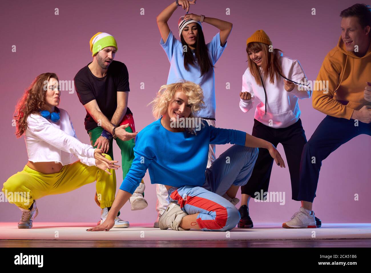 Group of men and women dancing hip hop choreography, showing cheerful