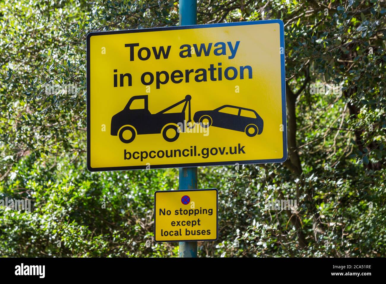 Tow away in operation and no stopping except local buses sign, road signs at Bournemouth, Dorset UK in August Stock Photo