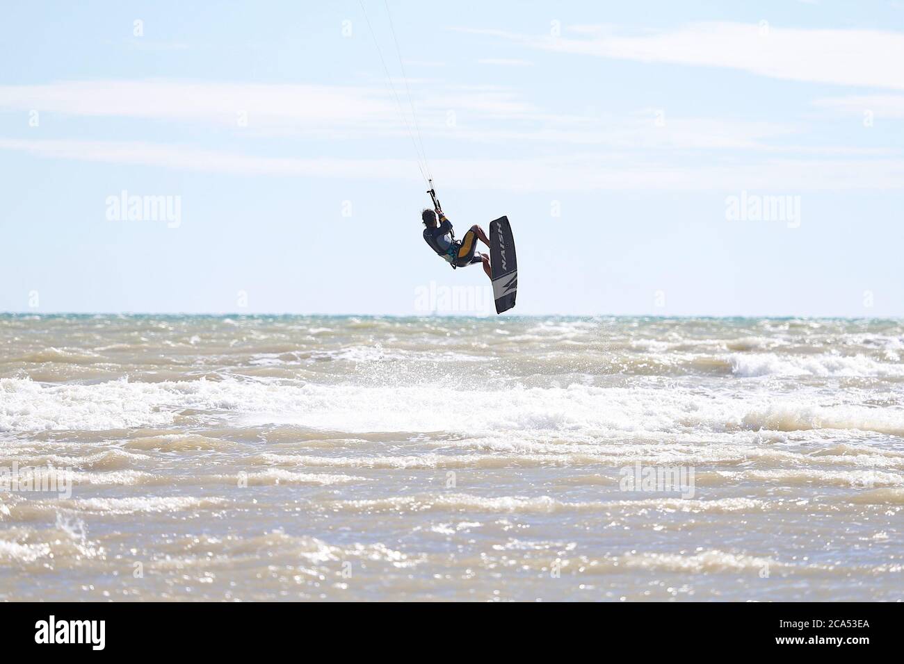 Camber, East Sussex, UK. 04 Aug, 2020. UK Weather: The wind has picked up which is Ideal for these kite surfers who take advantage of the blustery conditions before the predicted heatwave in the coming days. Photo Credit: Paul Lawrenson-PAL Media/Alamy Live News Stock Photo