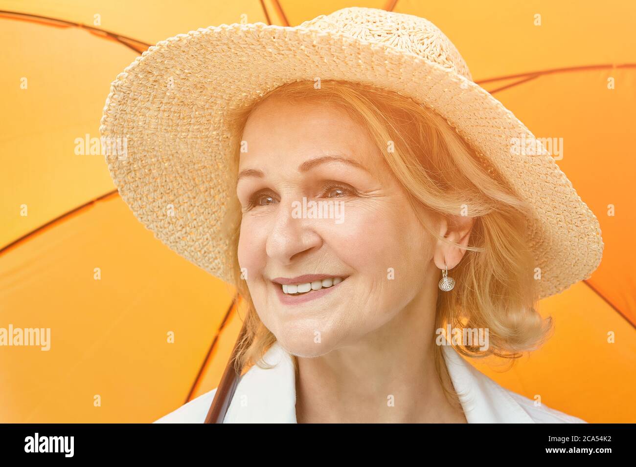 Elderly caucasian pretty woman about 60 years old in hat is smiling