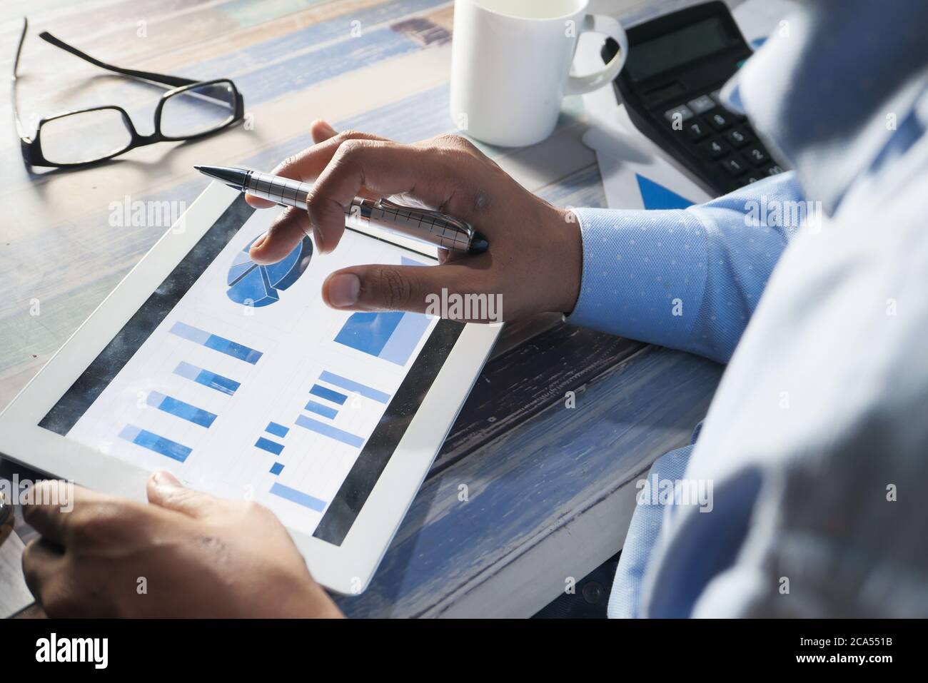 man's hand working on digital tablet at office desk, using self created ...