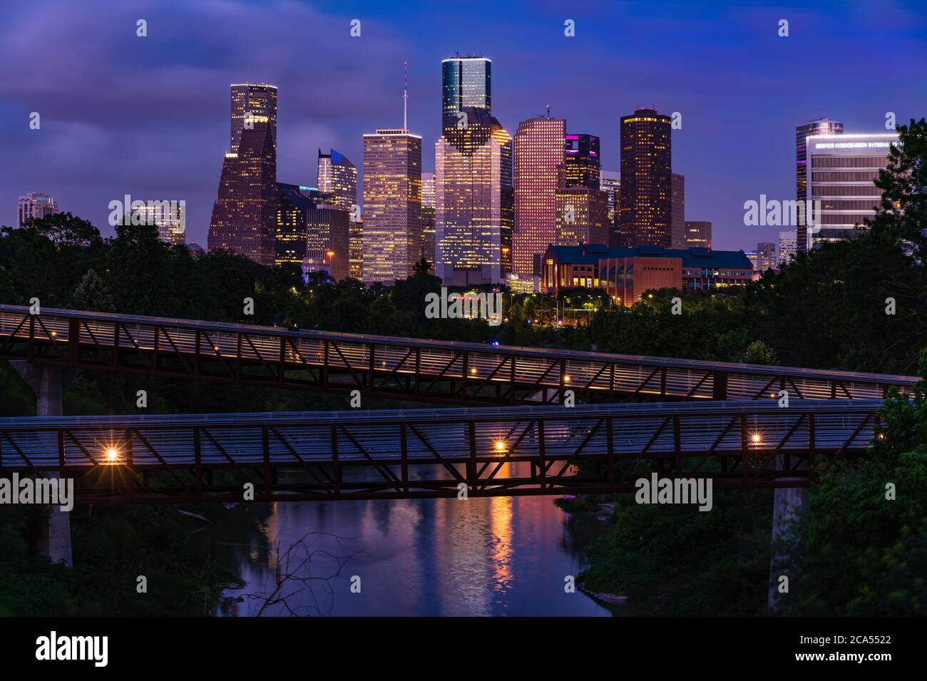 Elevated walkway over Buffalo Bayou at night with downtown skyline in background, Houston, Texas, USA Stock Photo