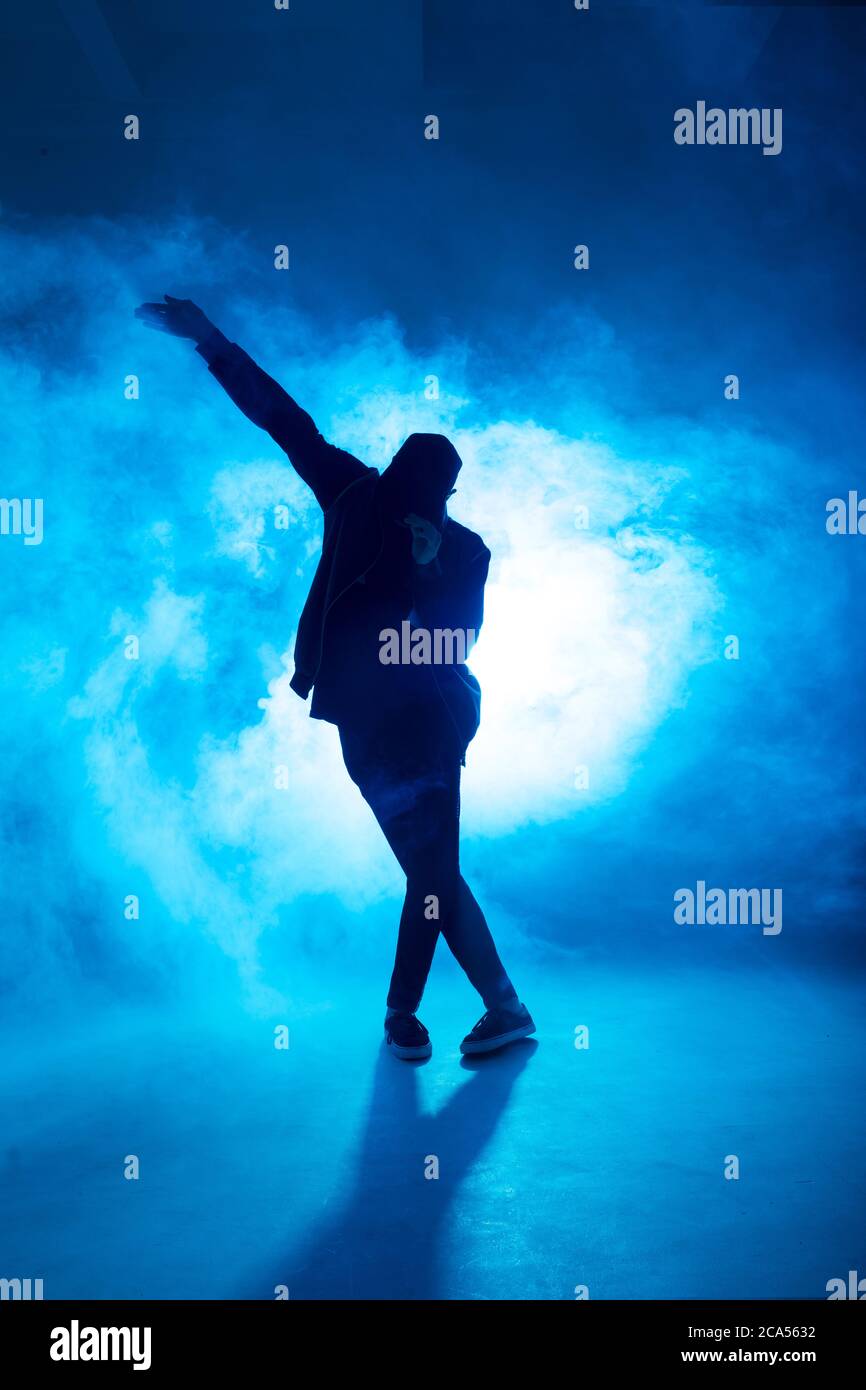 Full-size of silhouette of male break dancer performing on blue neon ...