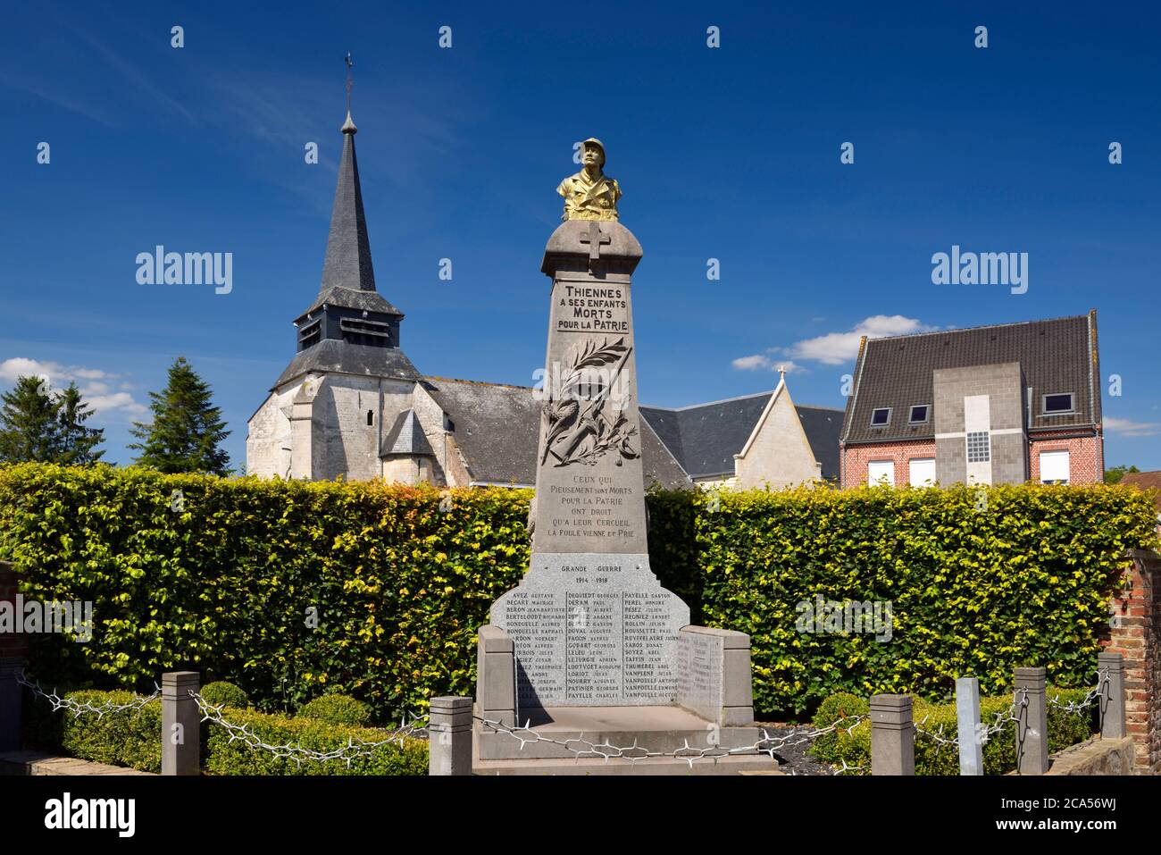 France, Nord, Thiennes, War memorial and church Saint-Pierre of Thiennes with a Flemish Gothic style built in 1550 Stock Photo