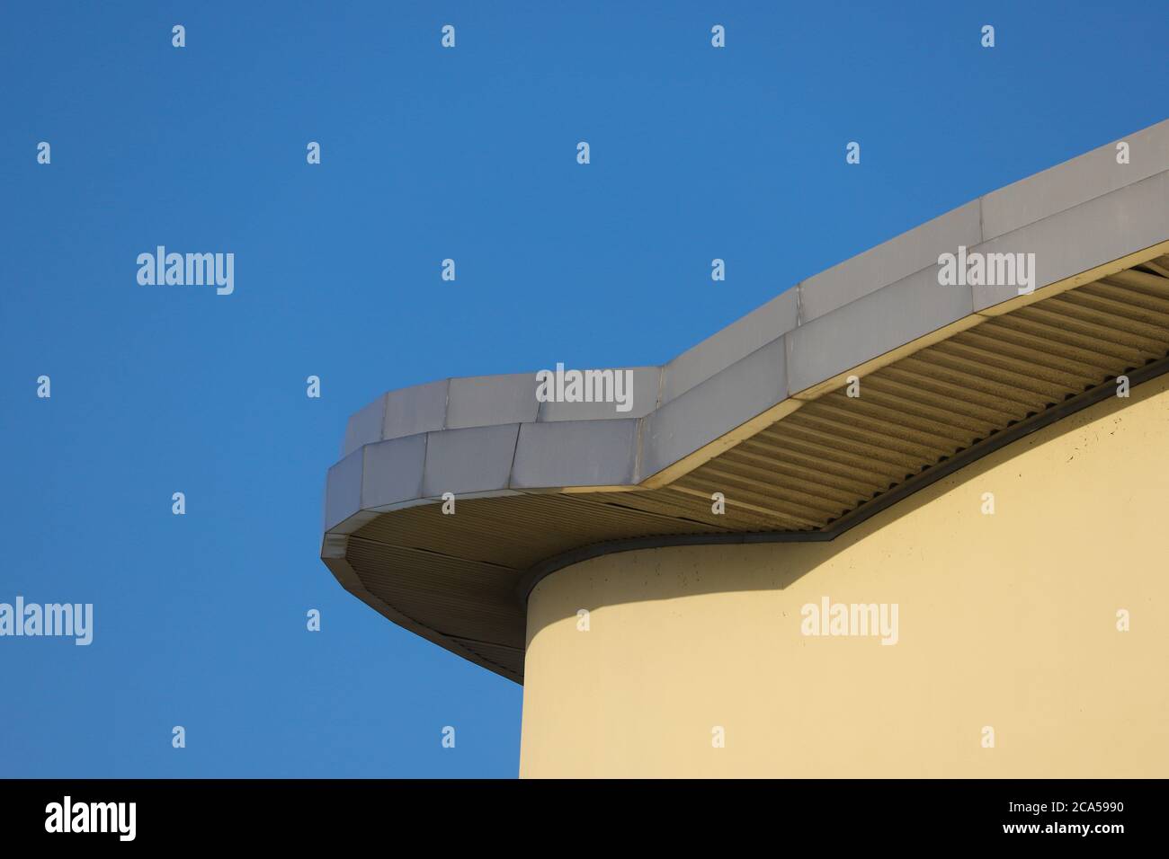 Lead roof of a curved apartment block against a clear blue sky Stock Photo