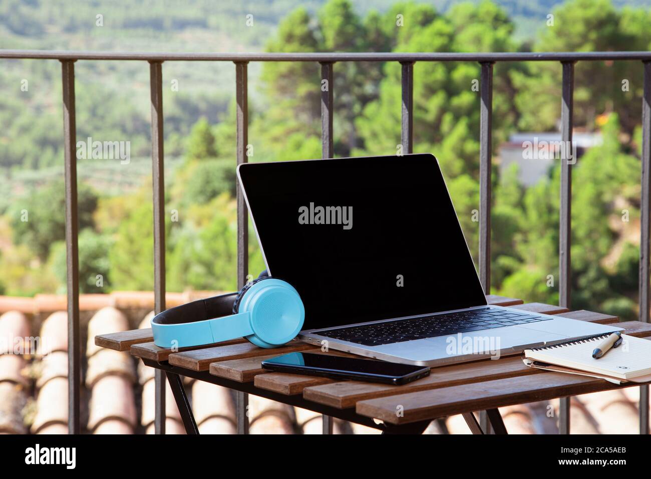 I work from the terrace of the house, table on the terrace with portable headphones and notepad. Stock Photo