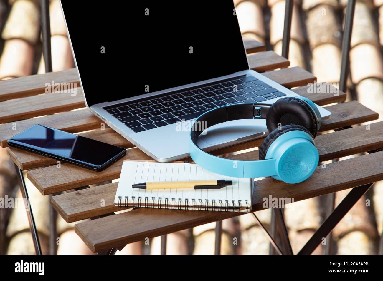 Isolated image of terrace table with portable headphones and notepad. I work from the terrace at home Stock Photo