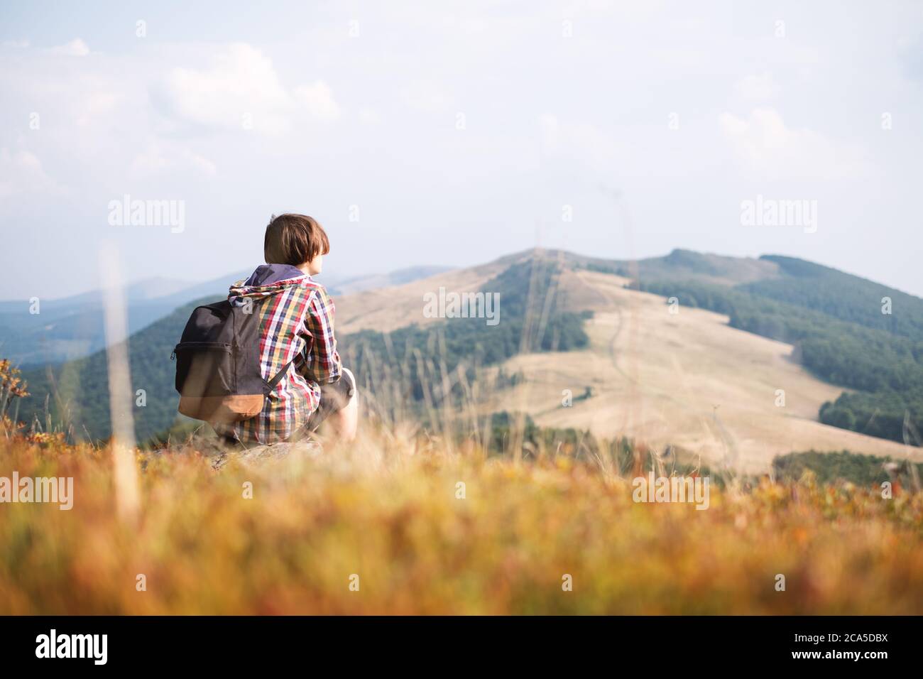 Boy with backpack in autumn mountains . Travel concept. Landscape photography Stock Photo