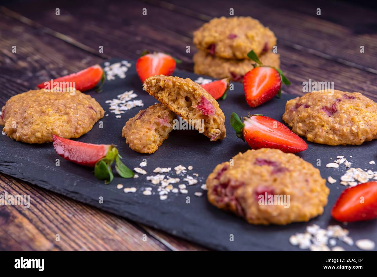 Homemade strawberry oatmeal cookies on black stone slate Stock Photo