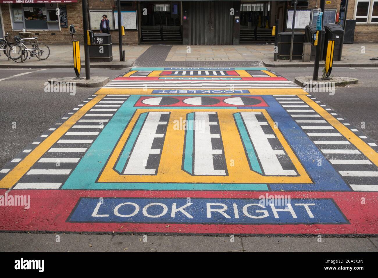 Closeup of French artist Camille Walala's geometric pedestrian crossings outside the entrance to White City underground station in west London, UK Stock Photo