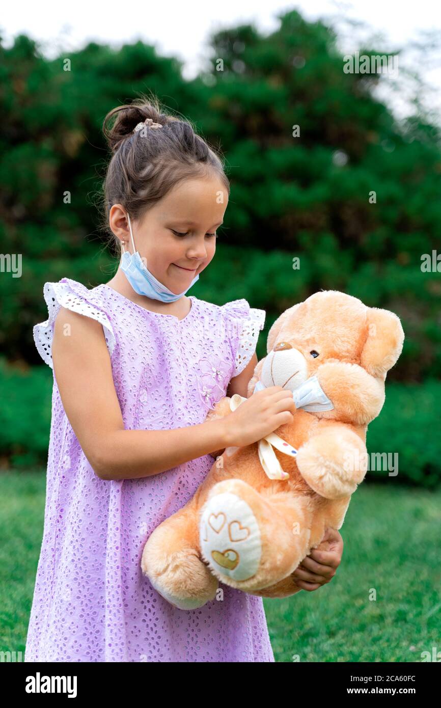 a girl and a toy in a mask. remove the mask. end of isolation. end of the epidemic Stock Photo