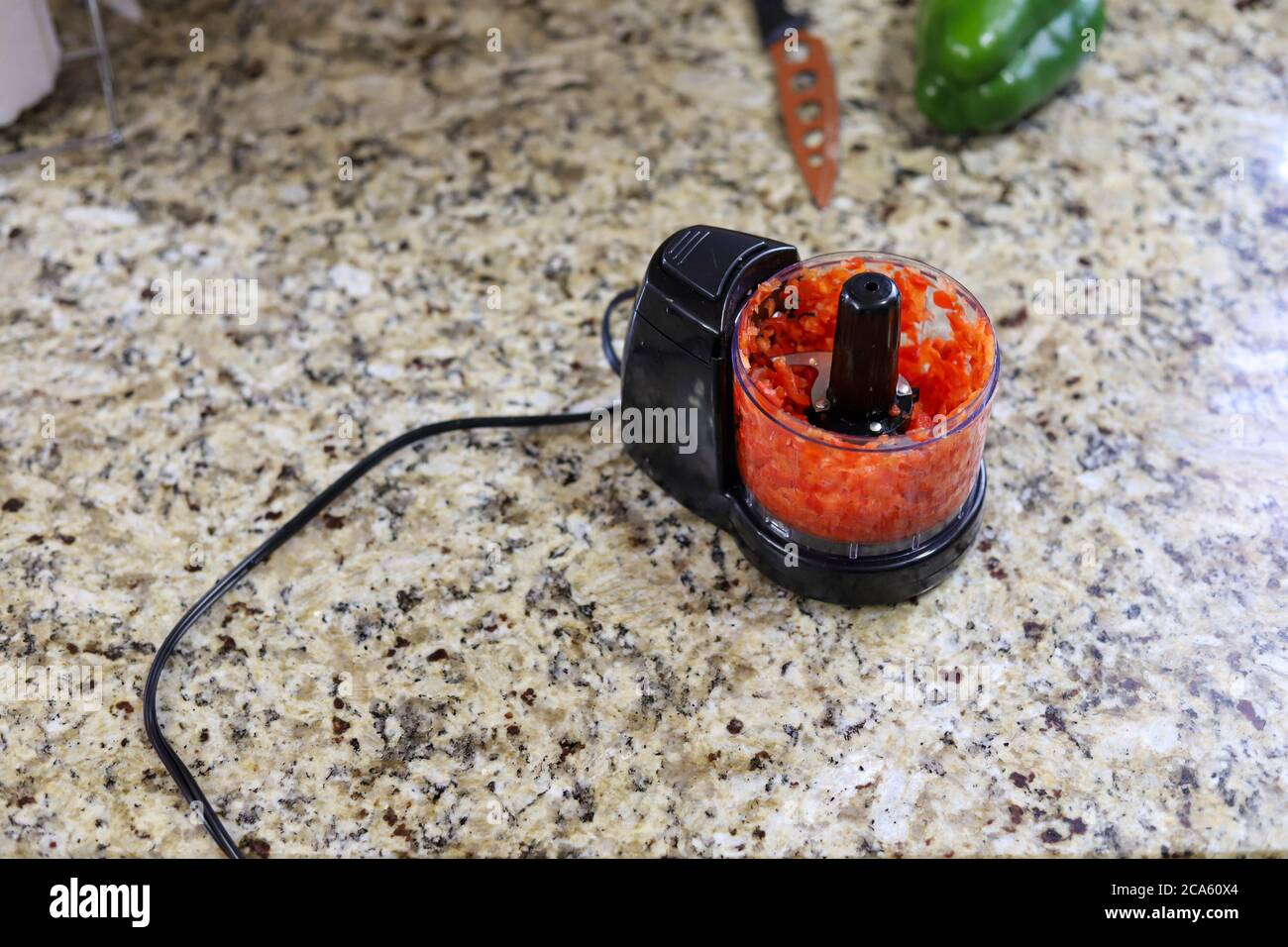 A organic red pepper in a food processor  on a kitchen counter Stock Photo