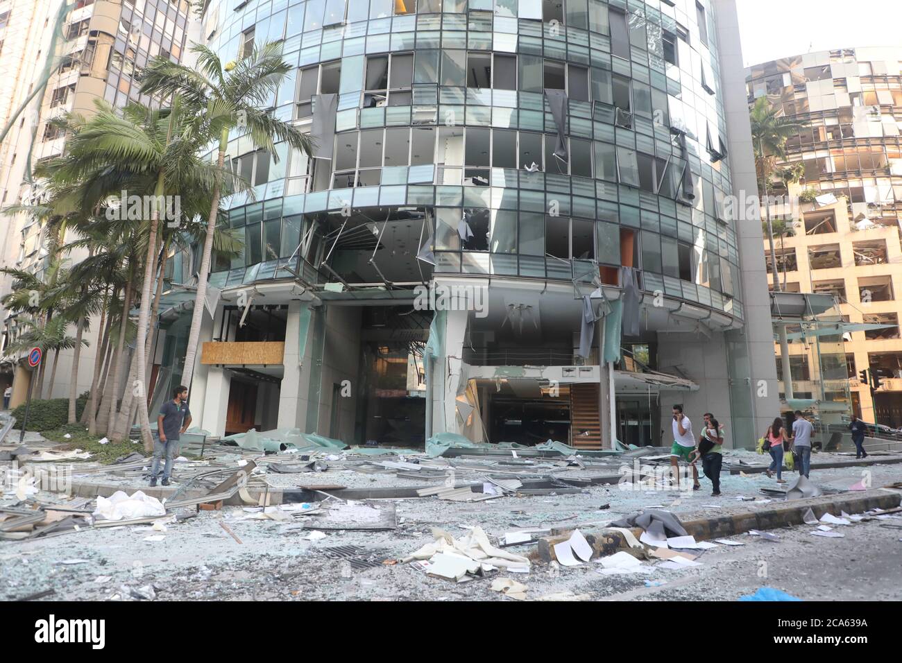 Beirut, Lebanon. 4th Aug, 2020. People walk past a destroyed building ...