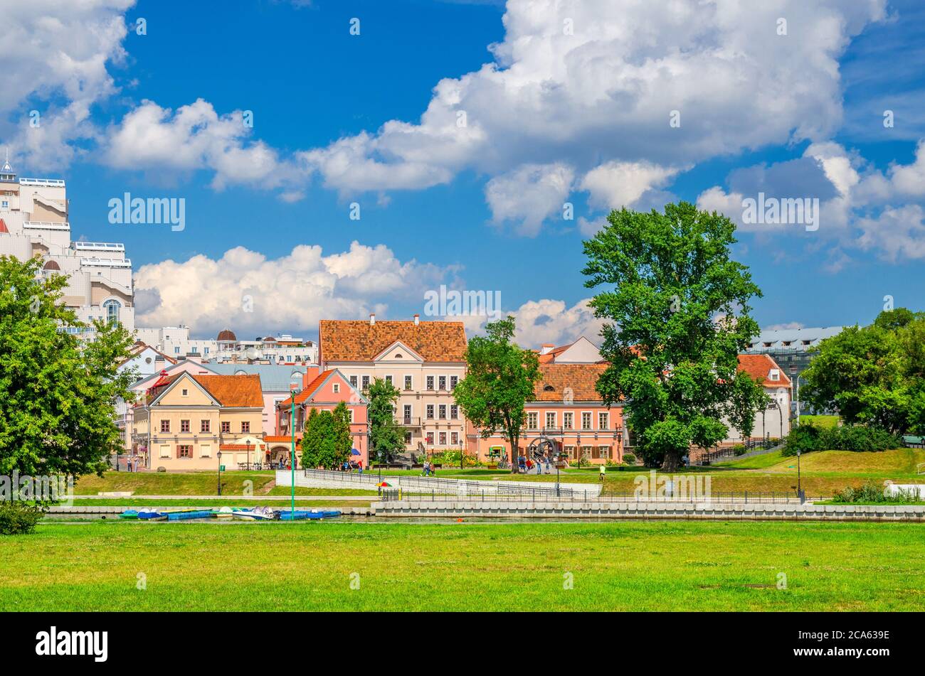 Traeckaje Suburb with old buildings in Trinity Hill district and grass lawn with green trees in Minsk city historical centre, blue sky white clouds in sunny summer day, Republic of Belarus Stock Photo