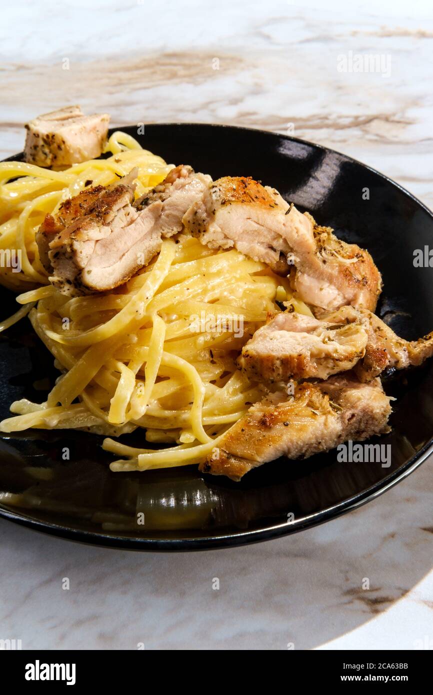 Authentic Italian chicken thigh fettuccine alfredo dinner Stock Photo