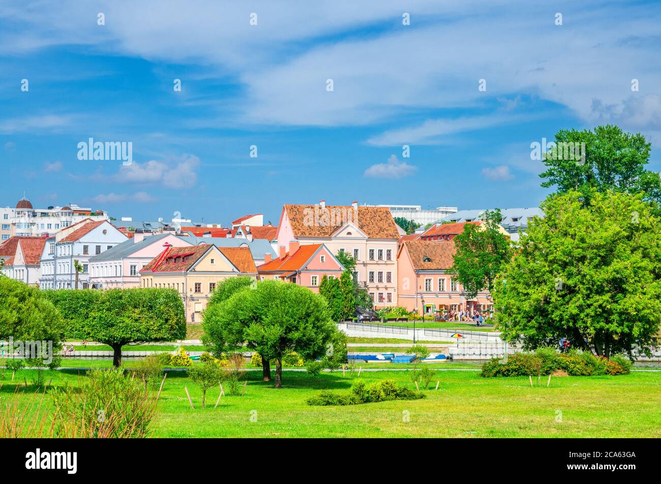 Traeckaje Suburb with old buildings in Trinity Hill district and grass lawn with green trees in Minsk city historical centre, blue sky white clouds in sunny summer day, Republic of Belarus Stock Photo