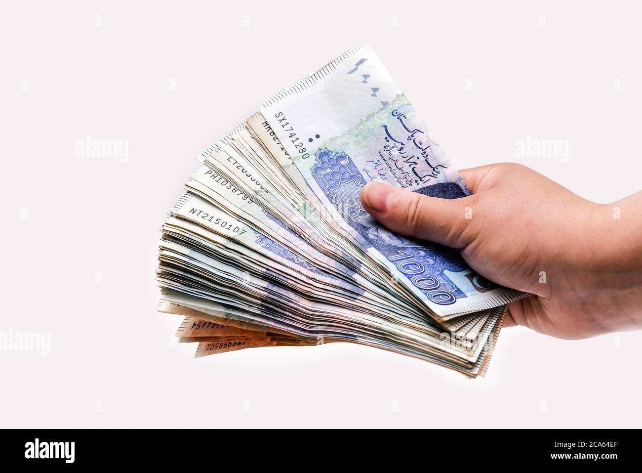 Lady holding Pakistani currency bank notes isolated on white background Stock Photo