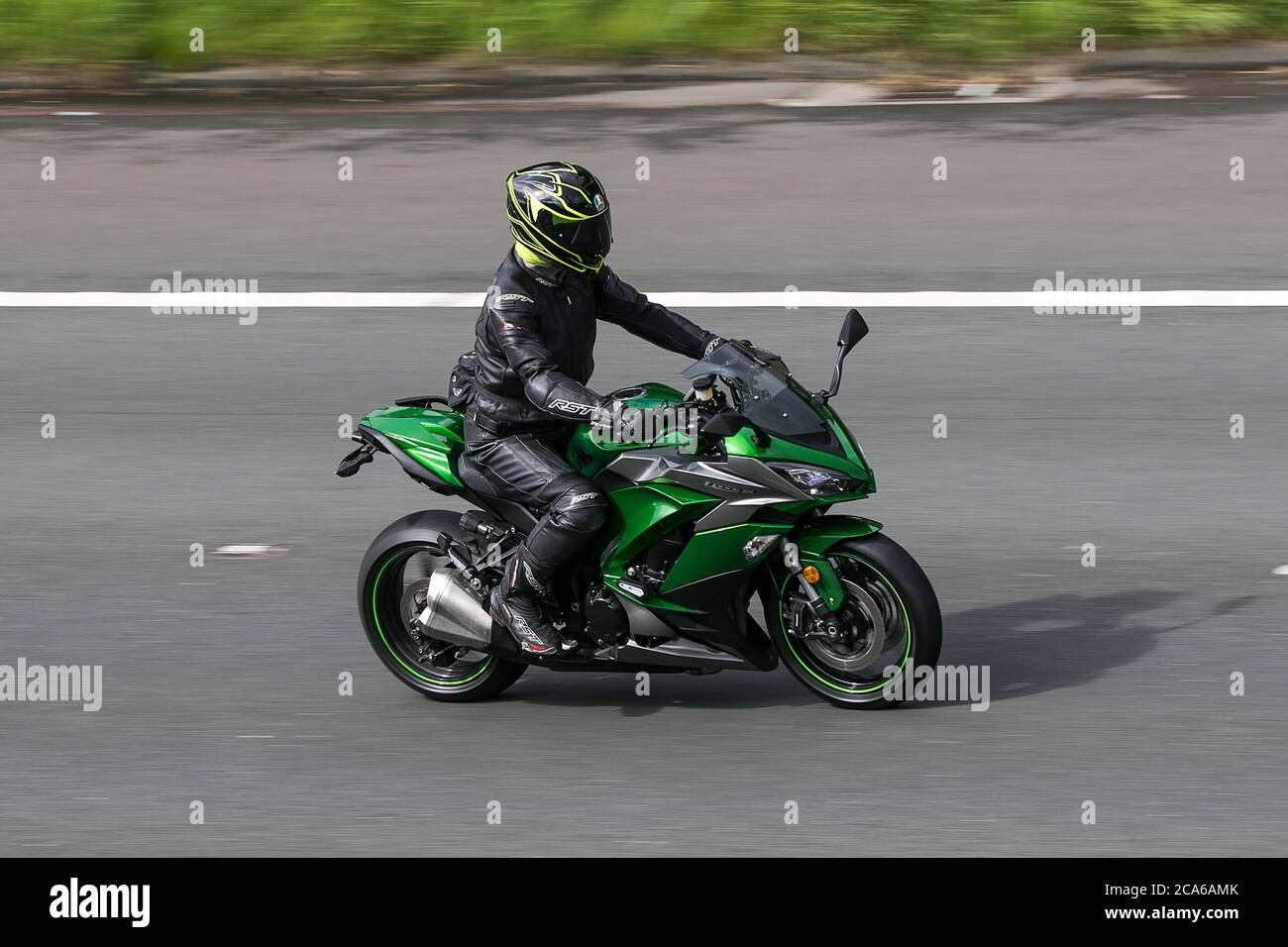 A Kawasaki motorbike and rider driving on the M6 motorway near Preston in Lancashire, UK Stock Photo