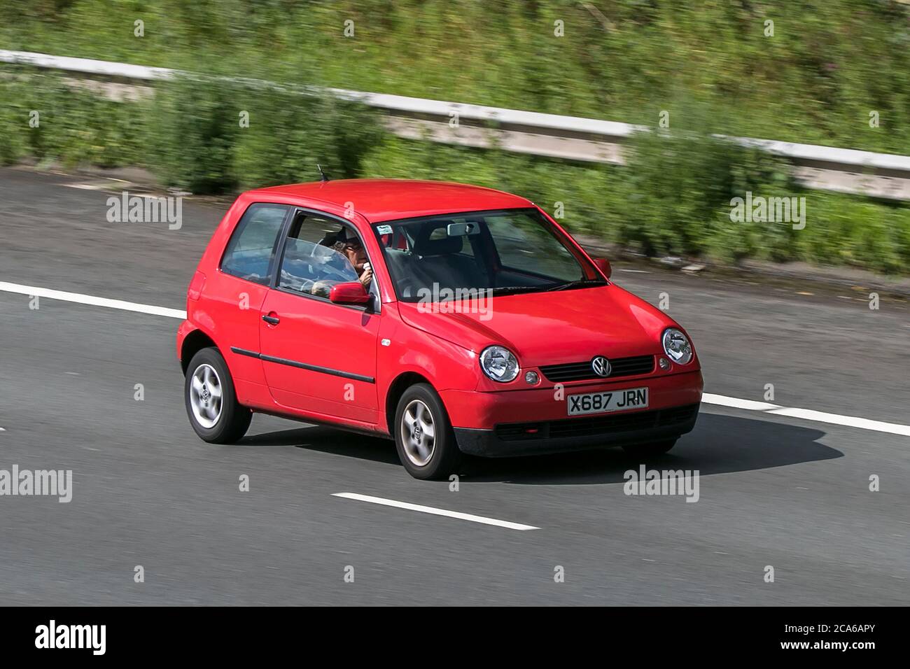 A 2000 Volkswagen Lupo E Red Car Hatchback Petrol driving on the M6 motorway near Preston in Lancashire, UK Stock Photo