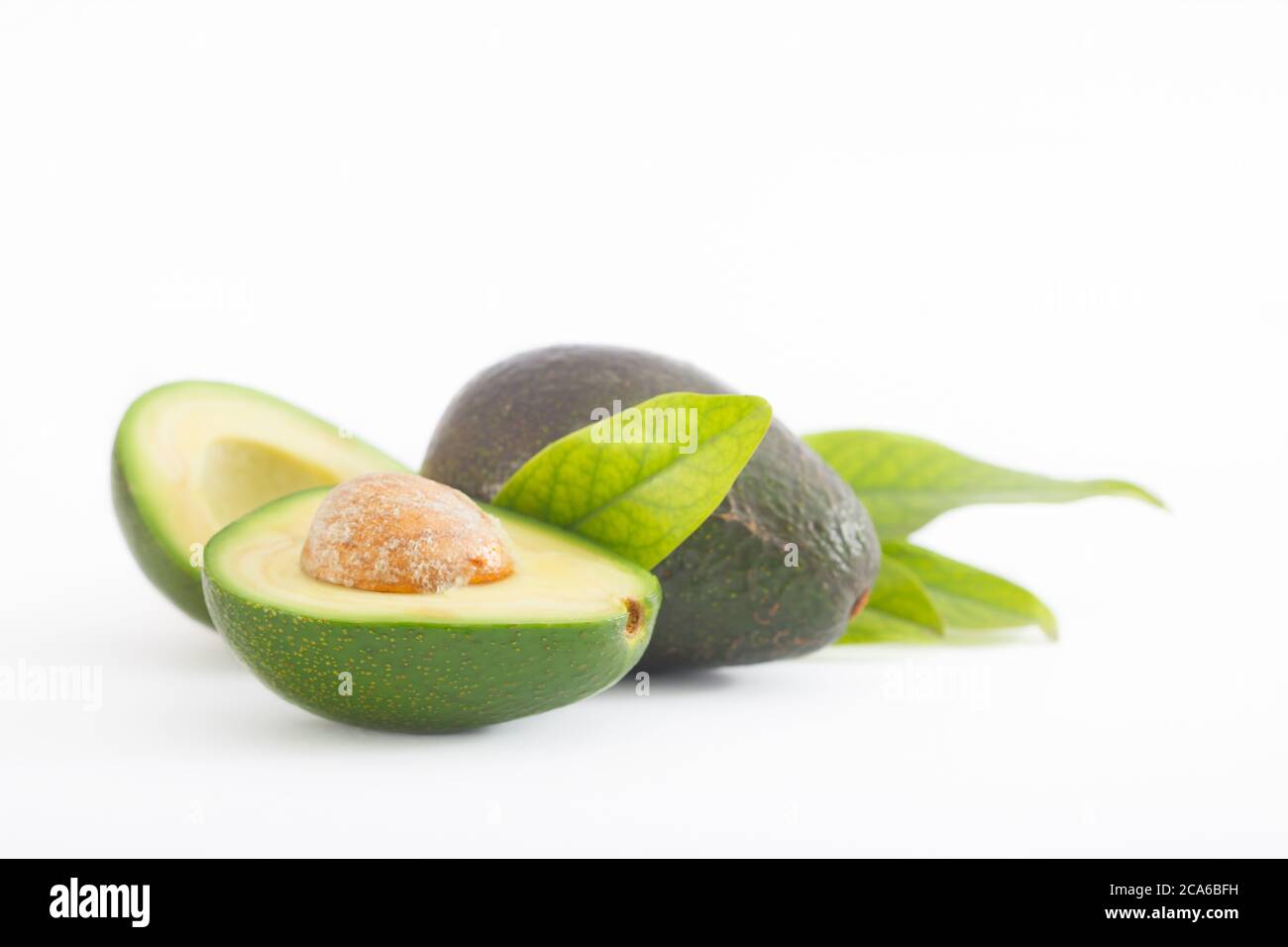 Avocado with leaves isolated on white background. Ripe, nutritious