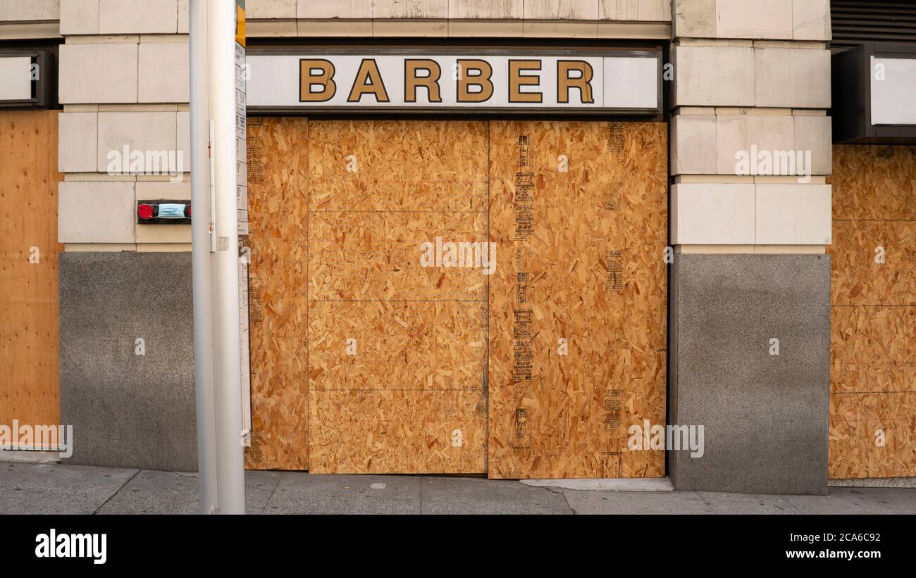 Wood sheets cover the entire store front of a downtown barber Stock Photo