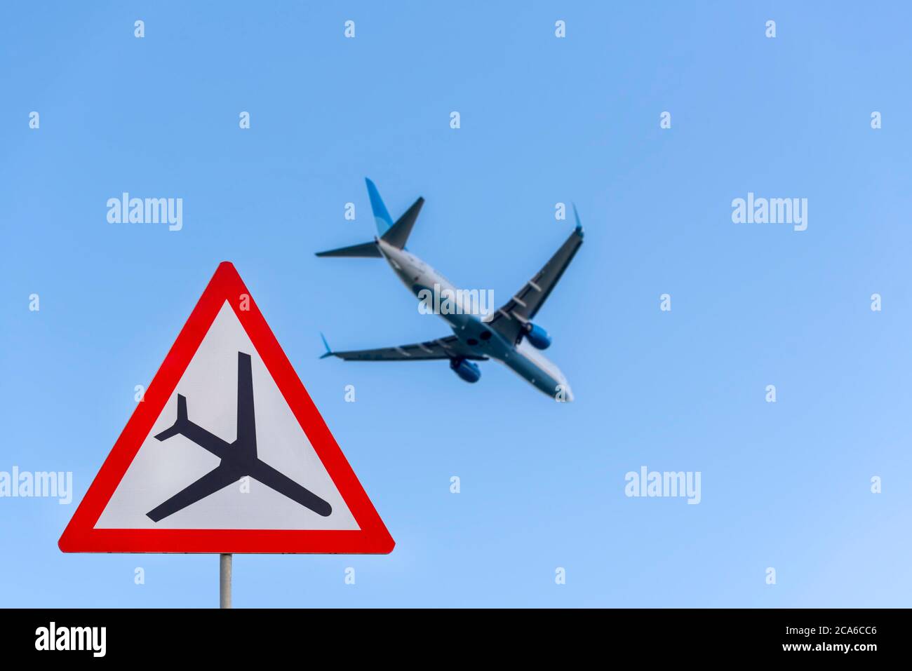 Airplane during take off and road airplane traffic sign, attention sign with plane, low flying