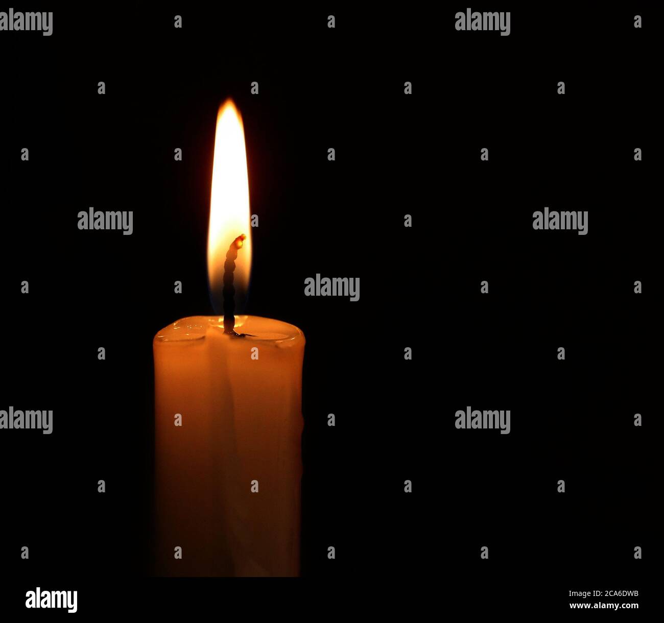 A lit candle in the darkness Stock Photo Alamy