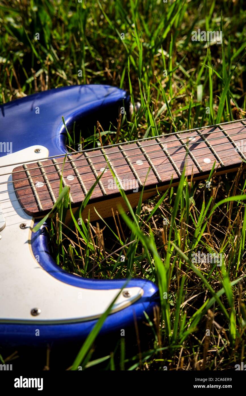 Blue electric guitar laying in grass on a sunny summer day Stock Photo -  Alamy