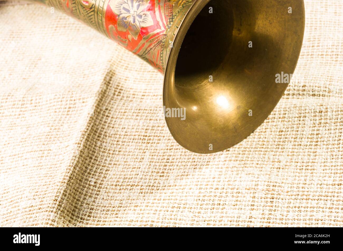 rustic coarse canvas fabric and a copper jug with ornament, close-up, background Stock Photo