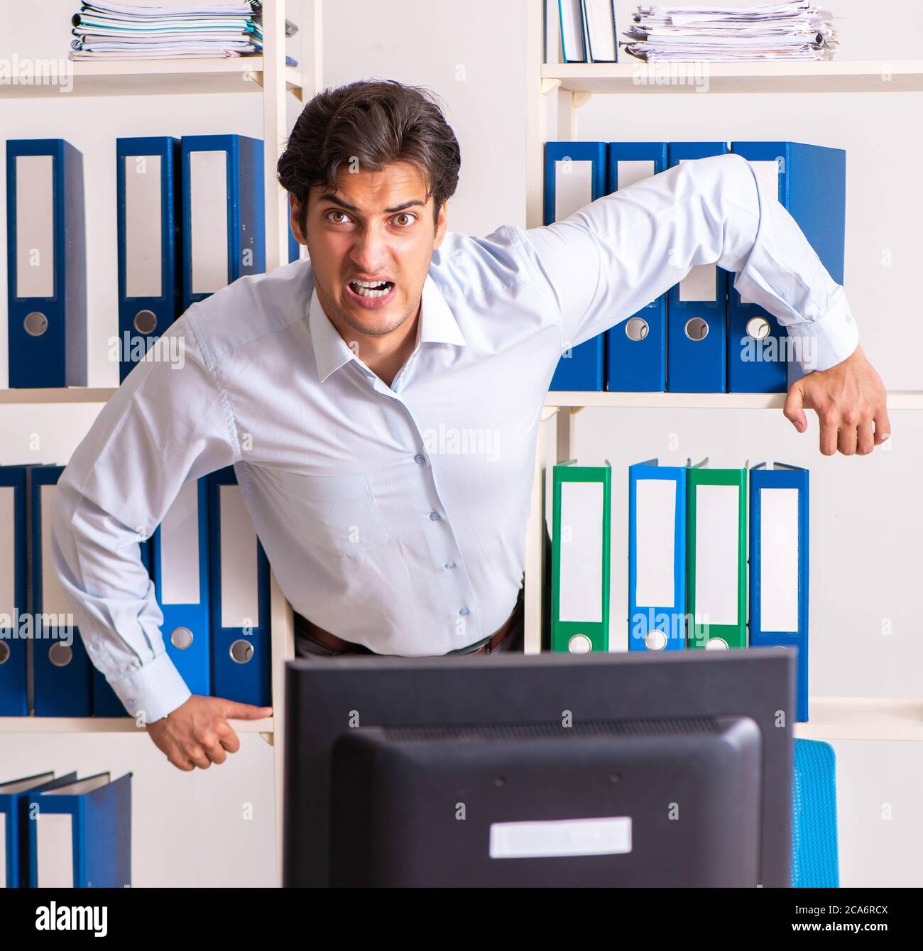 The young male employee working in the office Stock Photo