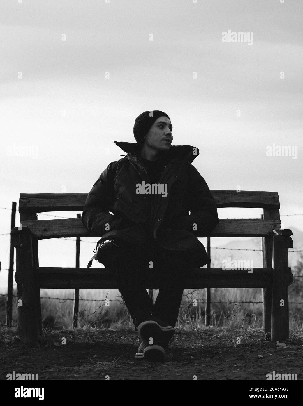 young man sitting on a bench black and white portrait Stock Photo - Alamy