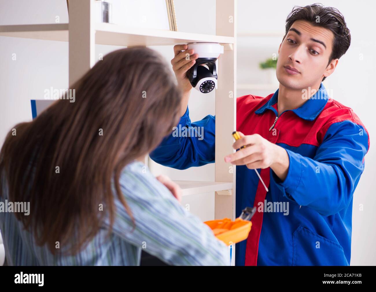 The client getting securty camera installed at home by contractor Stock Photo
