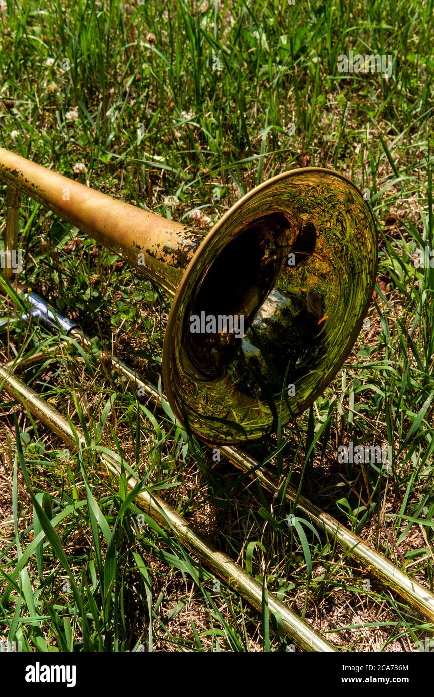 Old rusty trombone lays in grass field at music festival Stock Photo - Alamy