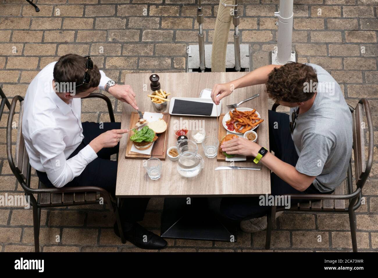 Diners eat food at outdoor restaurant tables in Kingly Court during the Eat Out to Help Out scheme offering diners a discount off meals to help boost restaurants and pubs post-lockdown. Stock Photo