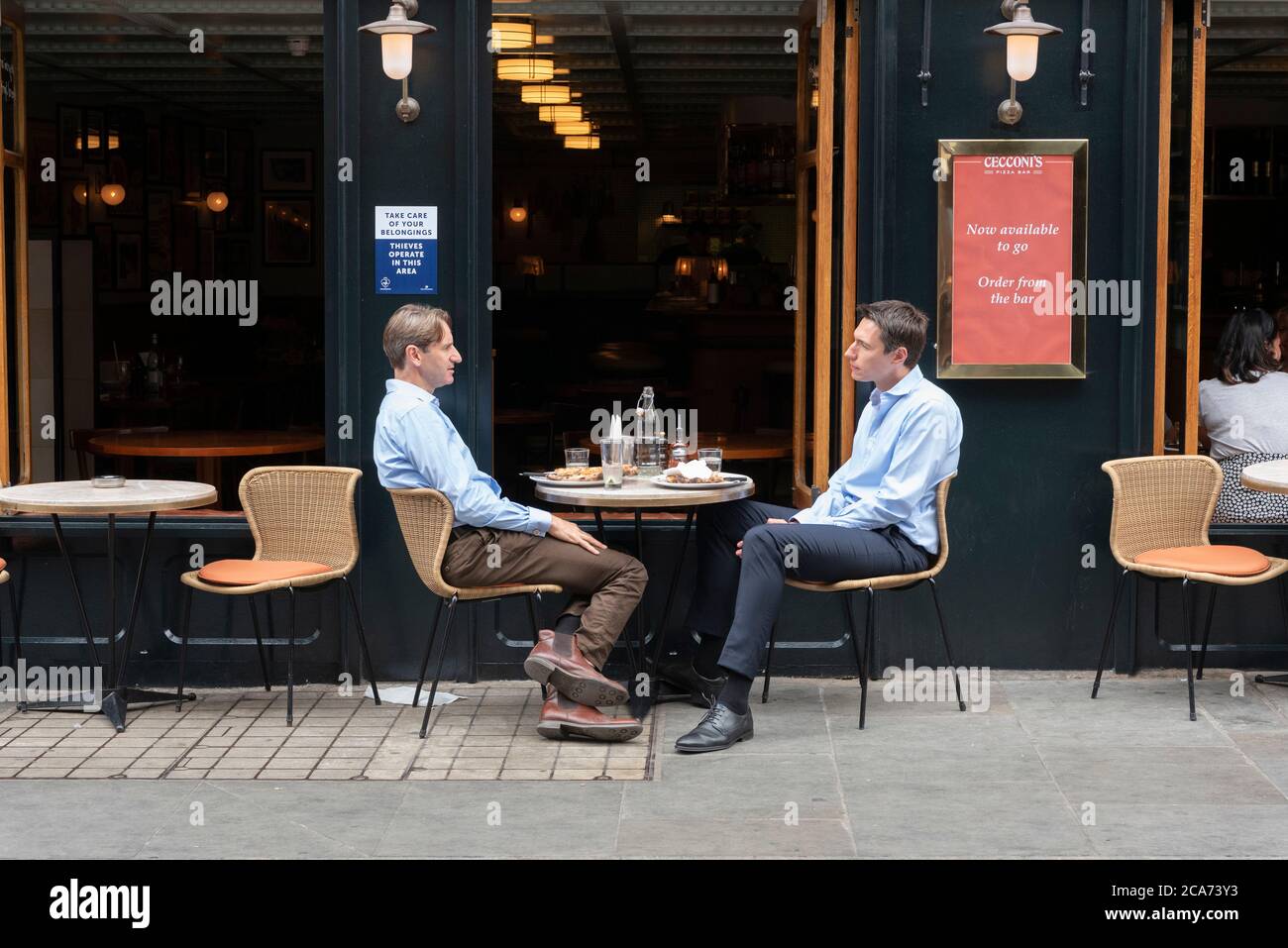 Diners eat food at outdoor restaurant tables in Soho during the Eat Out to Help Out scheme offering diners a discount off meals to help boost restaurants and pubs post-lockdown. Stock Photo