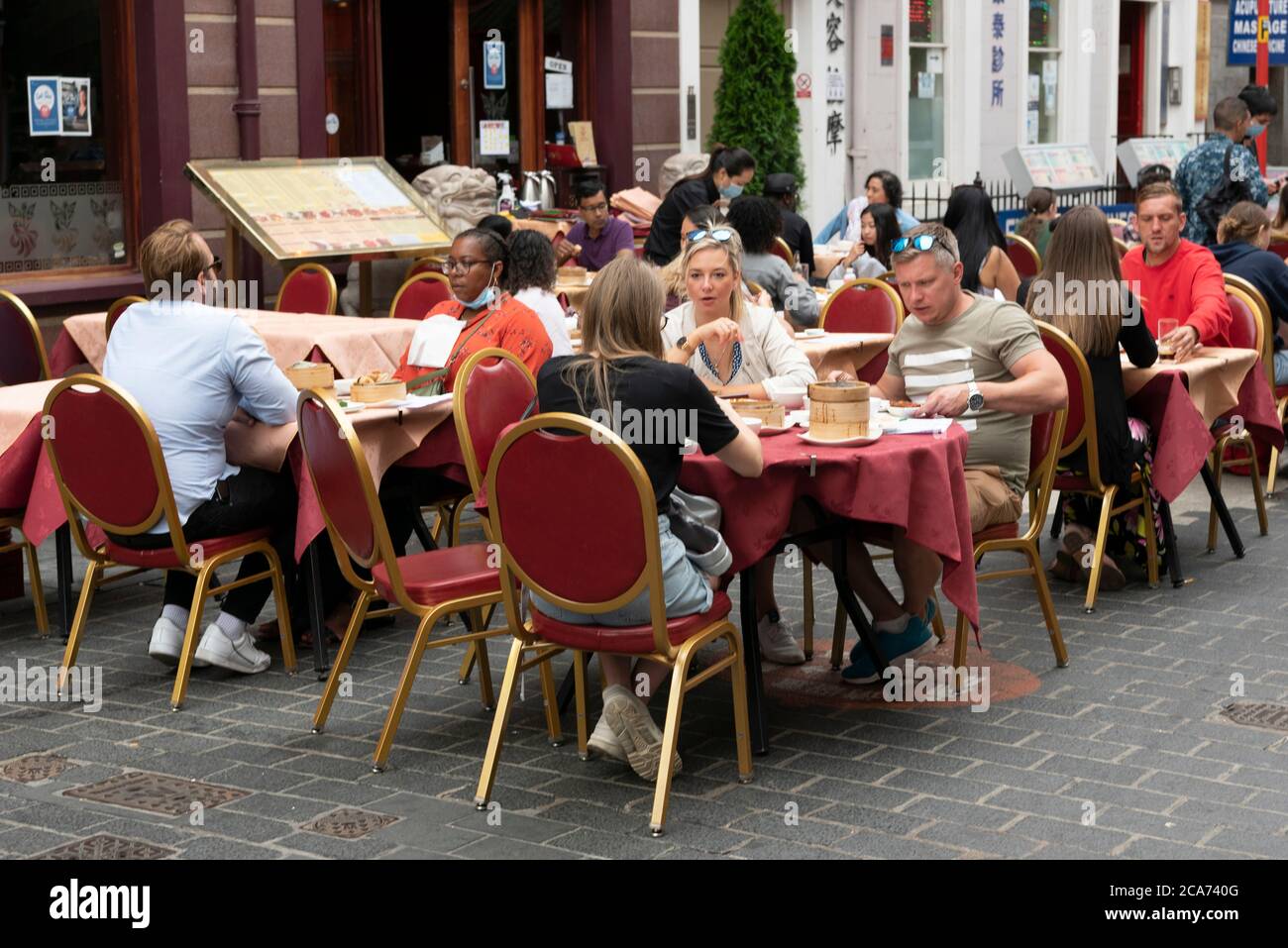 Diners eat food at outdoor restaurant tables in Chinatown during the ...