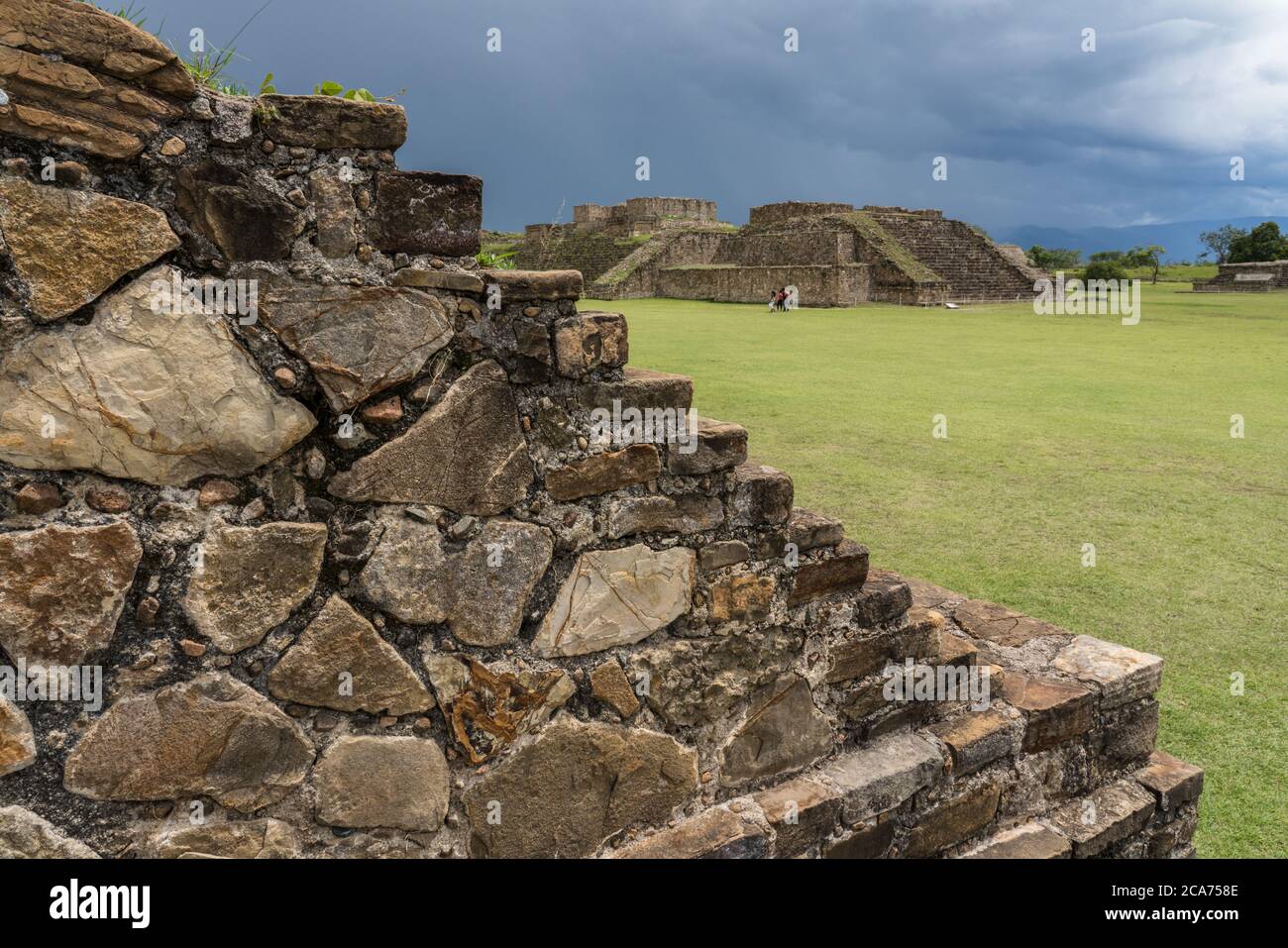 Detail of the stone steps leading to the ball court, looking across the Grand Plaza at Buildings G and H at the pre-Columbian Zapotec ruins of Monte A Stock Photo