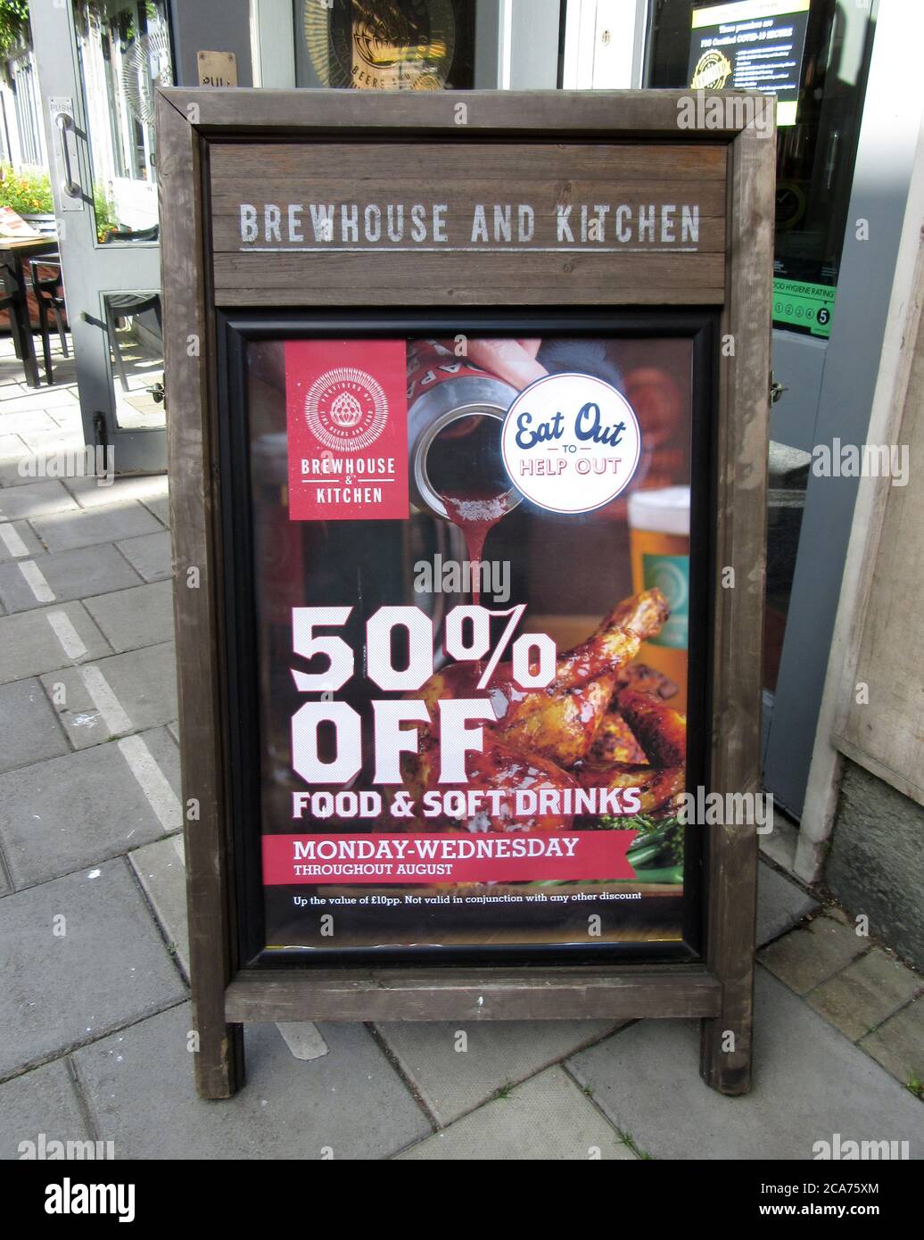 Board sign outside a Brewhouse and Kitchen restaurant informing people of their participation in the nationwide discount dining scheme.Pub Restaurants which have declared themselves as participating in the UK government's 'Eat Out to Help Out Scheme'. Diners receive a 50% discount, up to £10 each, on food or non-alcoholic drinks every Monday, Tuesday and Wednesday during August.  The scheme is to help boost the ailing hospitality industry which has been hit hard during the worldwide coronavirus pandemic. Stock Photo