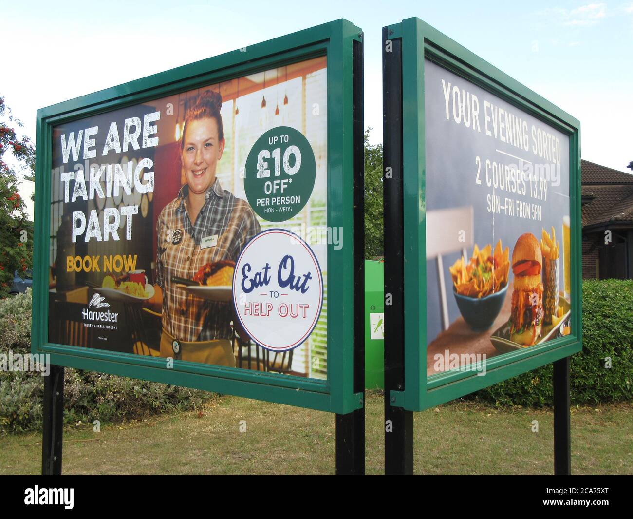 Large road signboard outside a Harvester restaurant informing people of their participation in the government discount scheme.Pub restaurants which have declared themselves as participating in the UK government's 'Eat Out to Help Out Scheme'. Diners receive a 50% discount, up to £10 each, on food or non-alcoholic drinks every Monday, Tuesday and Wednesday during August.  The scheme is to help boost the ailing hospitality industry which has been hit hard during the worldwide coronavirus pandemic. Stock Photo
