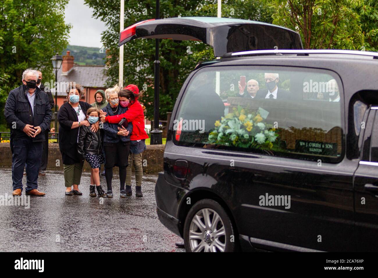 Londonderry, UK. 04th Aug, 2020. The wife and family of the late John Hume watch as his Wicker Coffin is removed from the hearse and taken into St Eugene's Cathedral ahead of his funeral on Wednesday 5th August. Credit: Bonzo/Alamy Live News Stock Photo