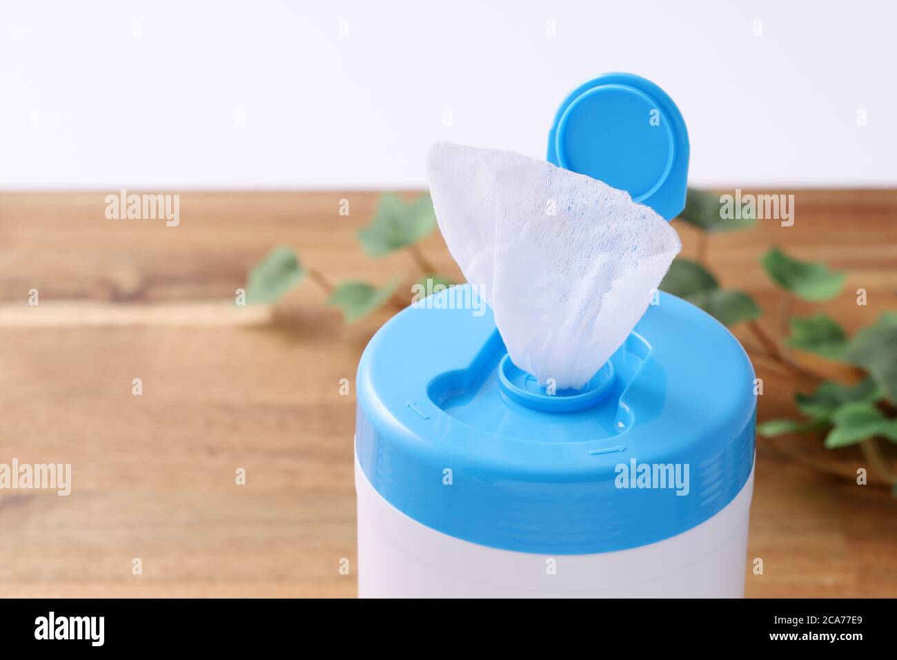 plastic tube shaped box of wet tissue paper on wooden table Stock Photo