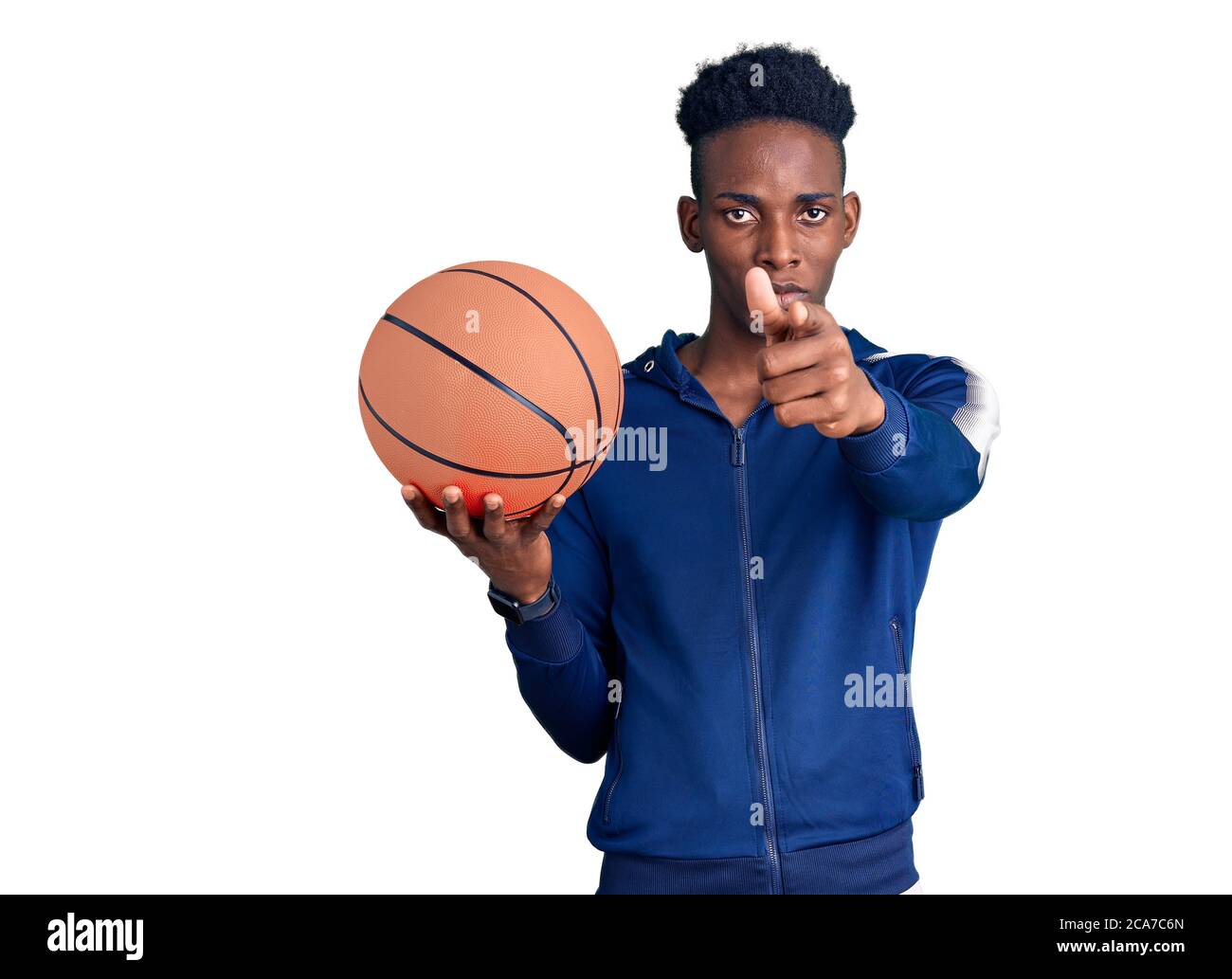 Young african american man holding basketball ball pointing with finger to the camera and to you