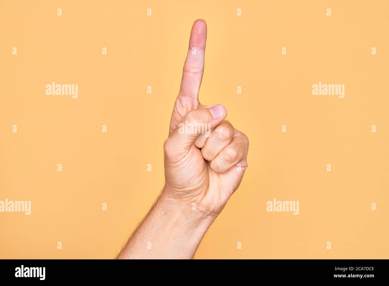 Hand of caucasian young man showing fingers over isolated yellow ...