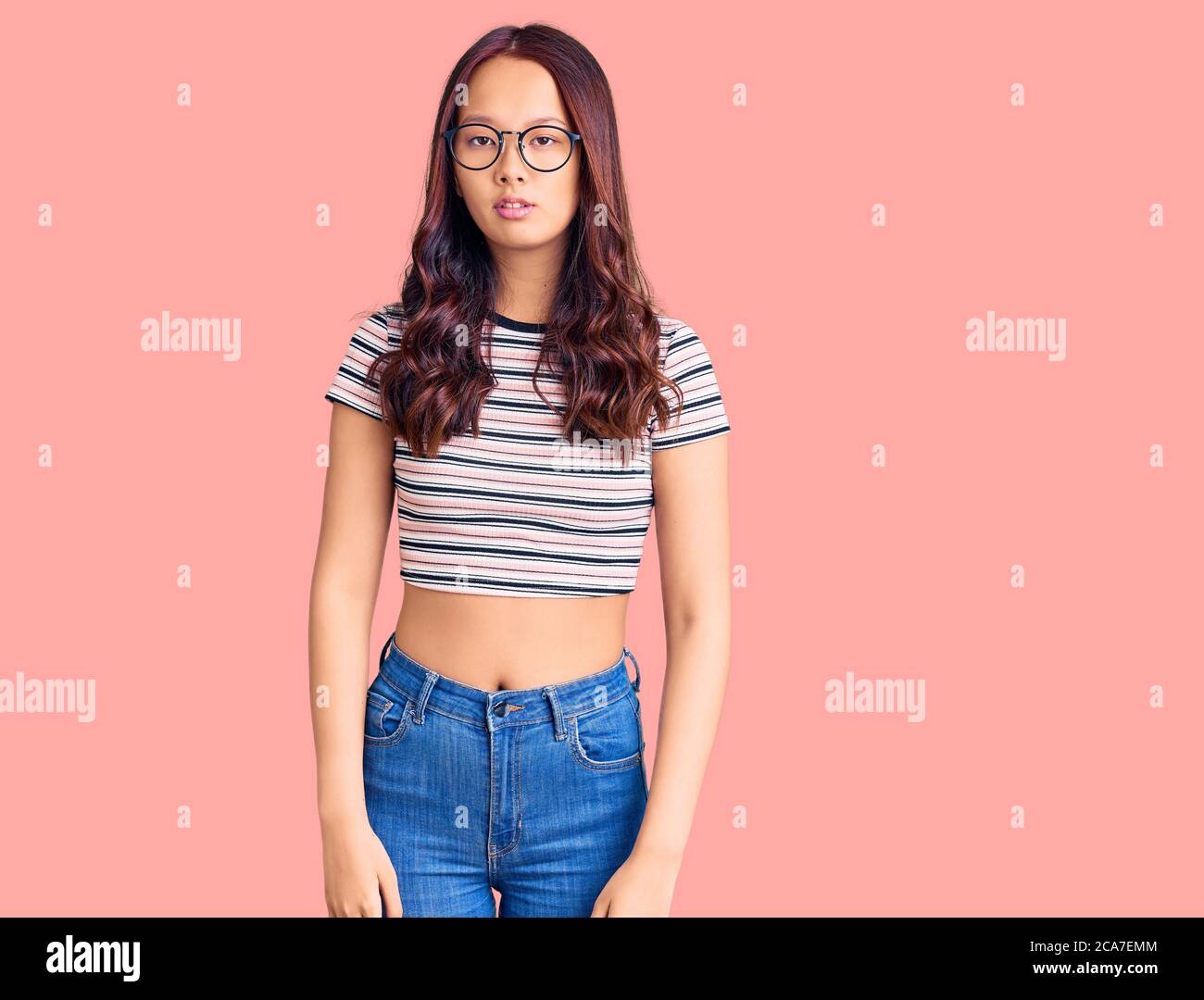 Young beautiful chinese girl wearing casual clothes with serious 